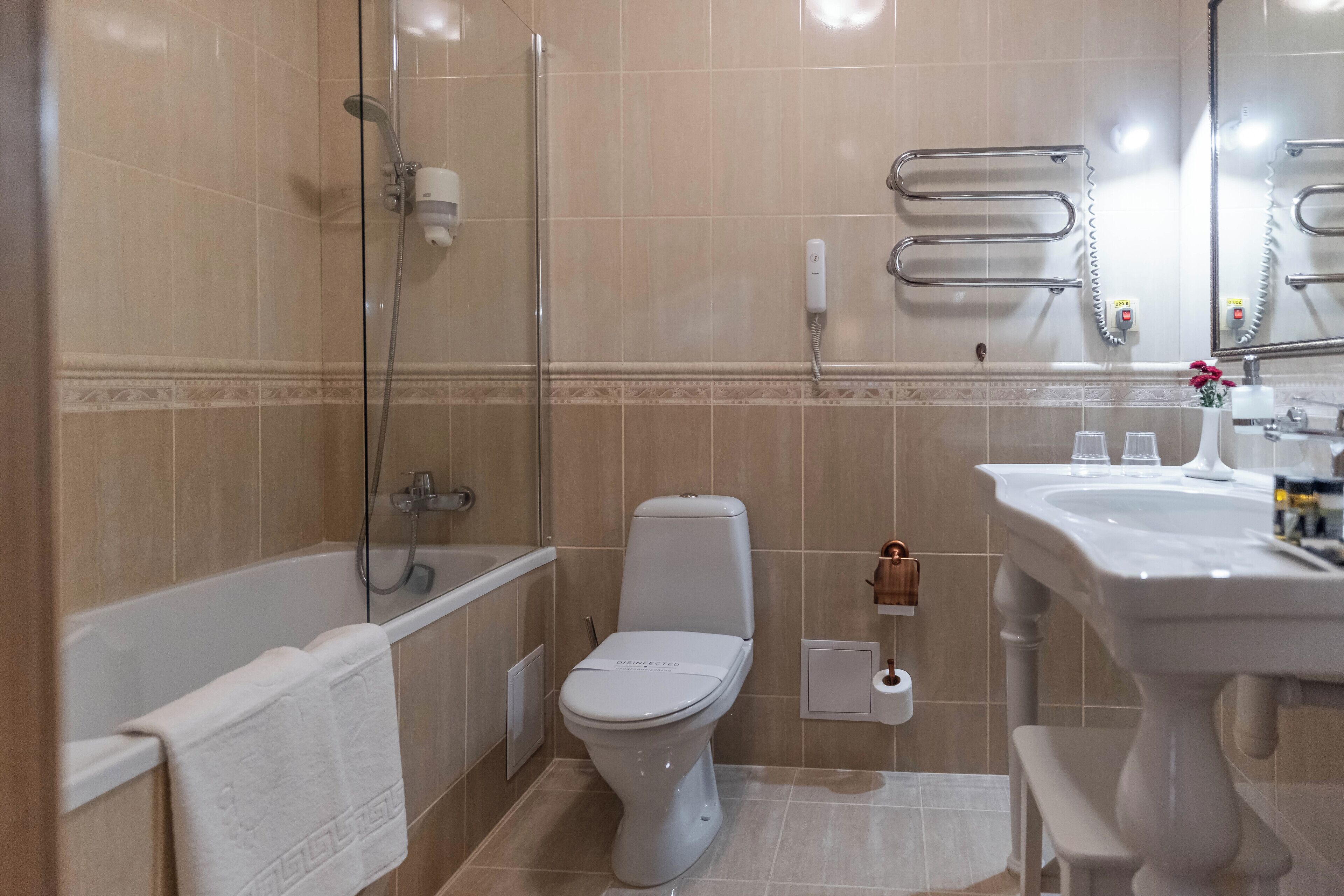 Et badeværelse med badekar, toilet og håndvask.