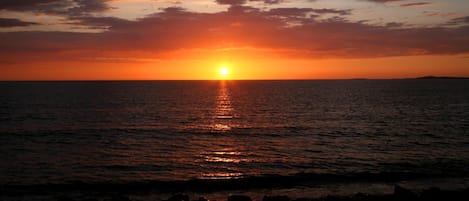 Un atardecer sobre el océano con un horizonte despejado y sin tierra a la vista.