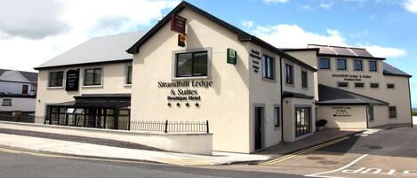 A building with signage for Strandhill Lodge & Suites Boutique Hotel.