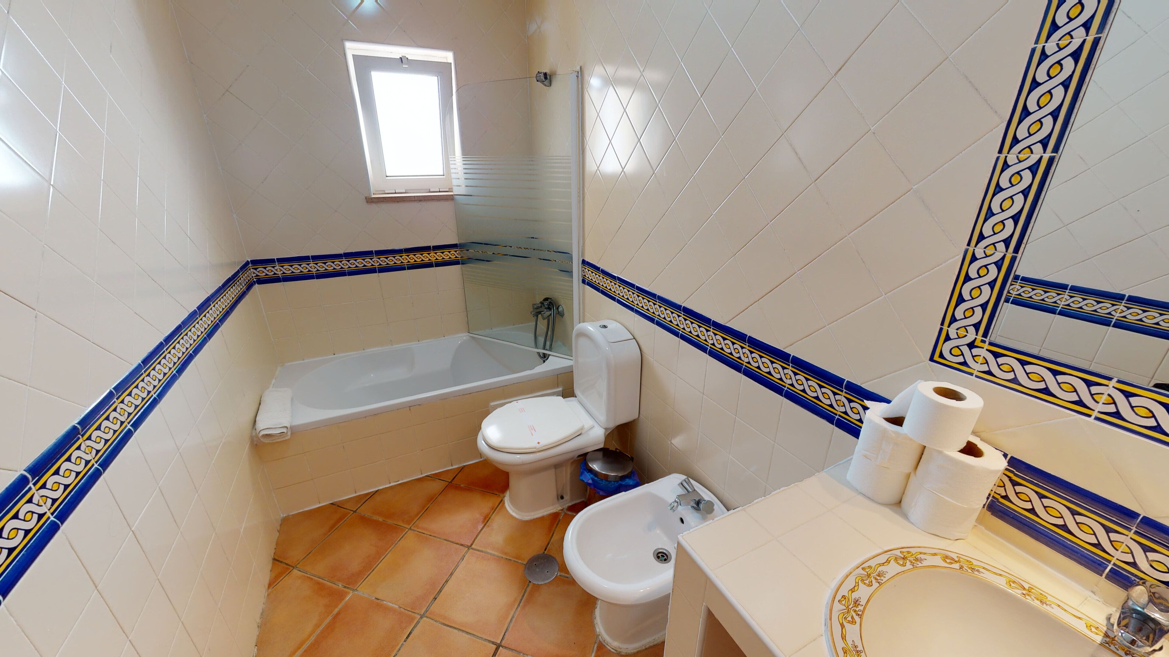 A bathroom with a bathtub, toilet, bidet, and sink.