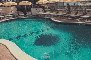 A swimming pool with lounge chairs and umbrellas. - Hotel Insonnia (Agropoli)