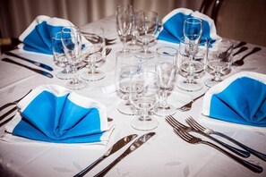 A table set for a formal dinner with multiple wine glasses, forks, and knives. - Hotel Insonnia (Agropoli)