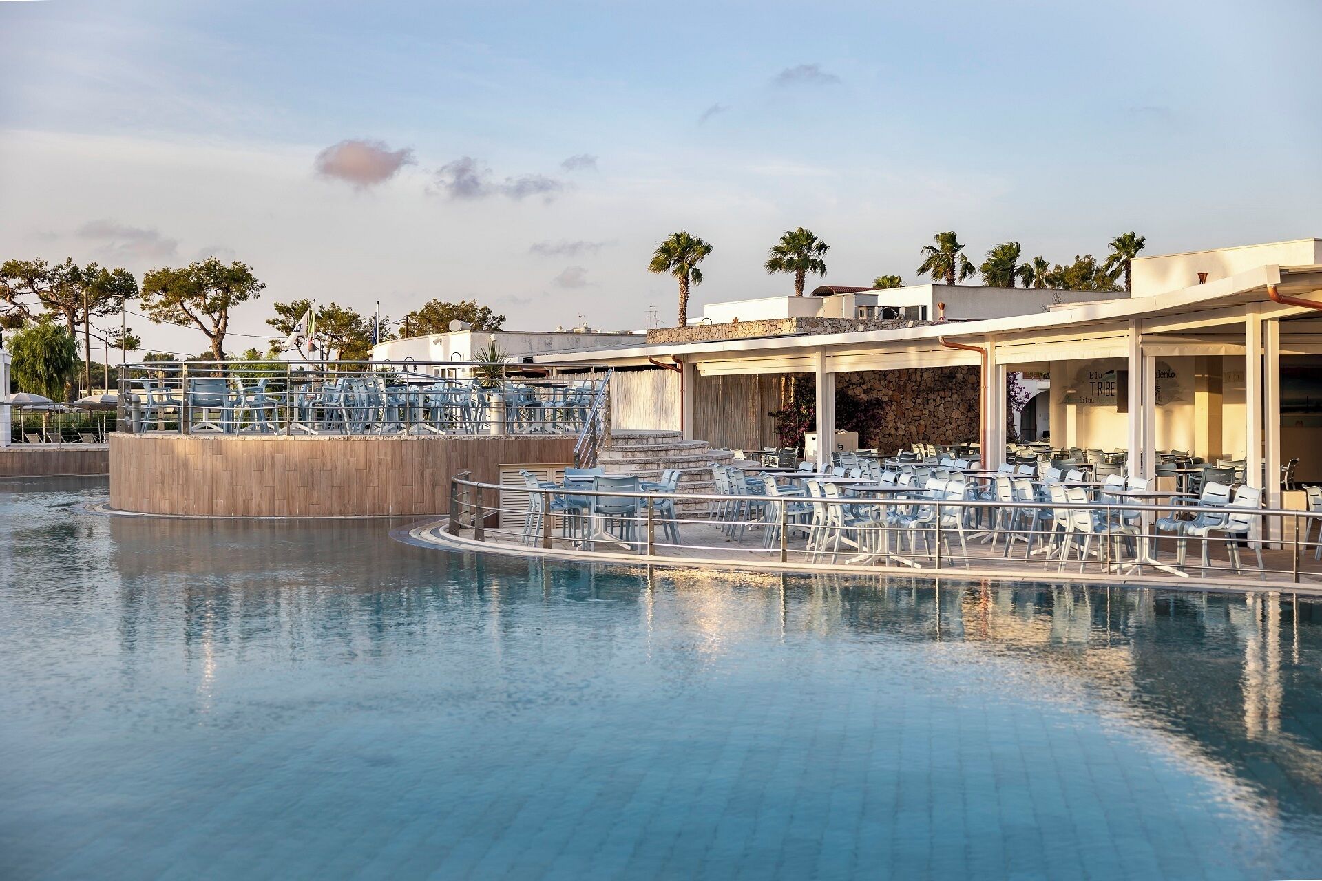 A poolside area with lounge chairs and a covered seating area.