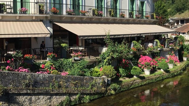 A restaurant named CHARBONNEL with outdoor seating and a canal view.