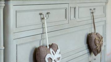 A white dresser with heart-shaped decorations and a bust sculpture.