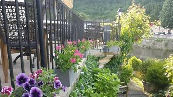 Un sendero en un jardín con plantas en macetas y un banco.
