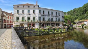A two-story building with a restaurant and hotel named "HOTEL CHABROL RESTAURANT CHARBONNEL" on the ground floor.
