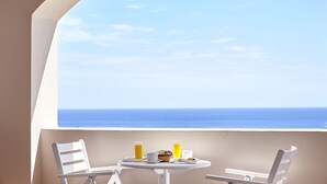 A balcony with a table set for breakfast, overlooking a clear blue sky and ocean. - Terra Blue Santorini (Santorini)