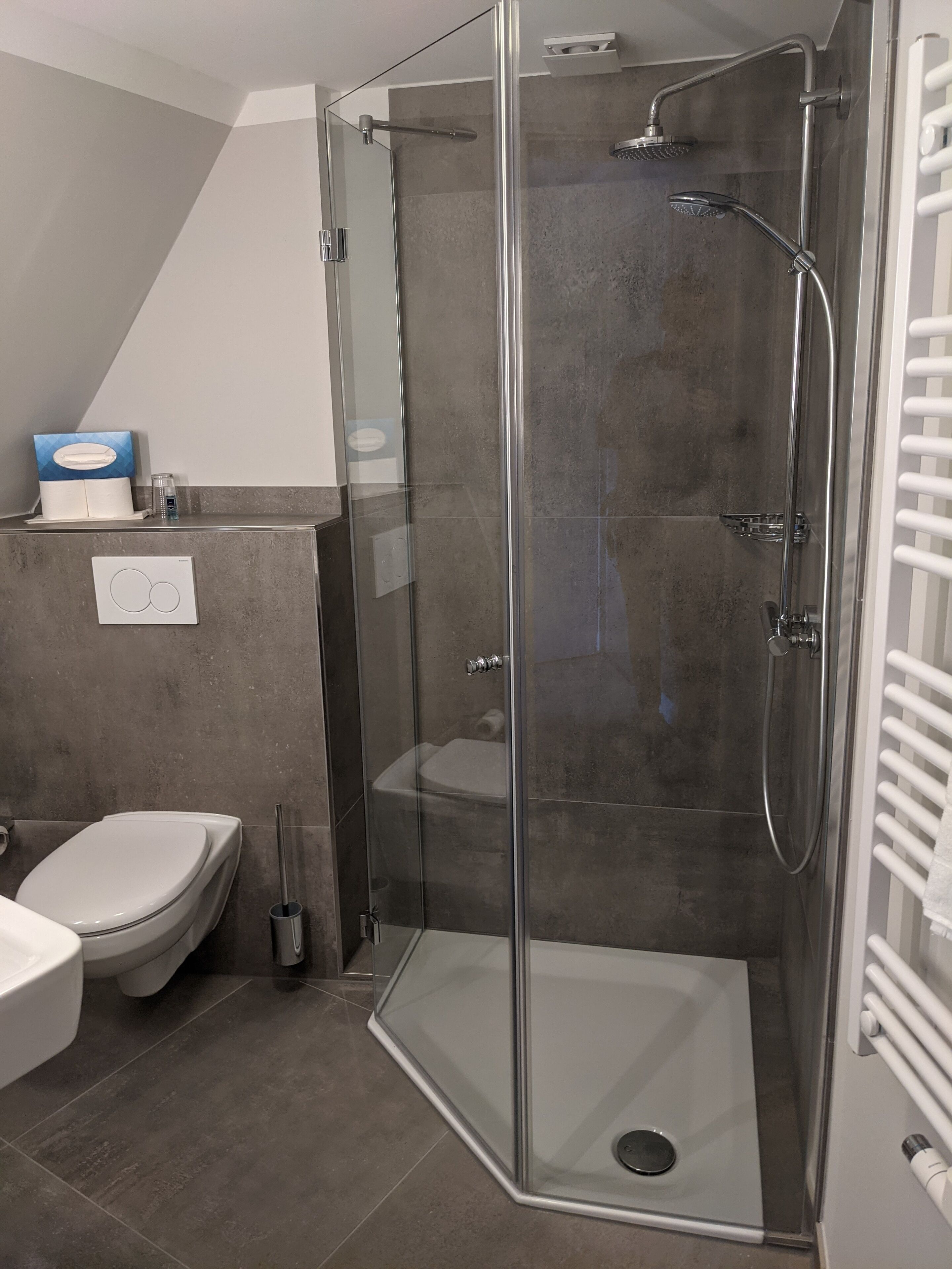 Un bagno moderno con doccia vetrata, toilette e lavandino.