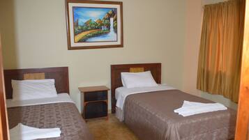 A hotel room with two beds, a nightstand, and a painting on the wall.