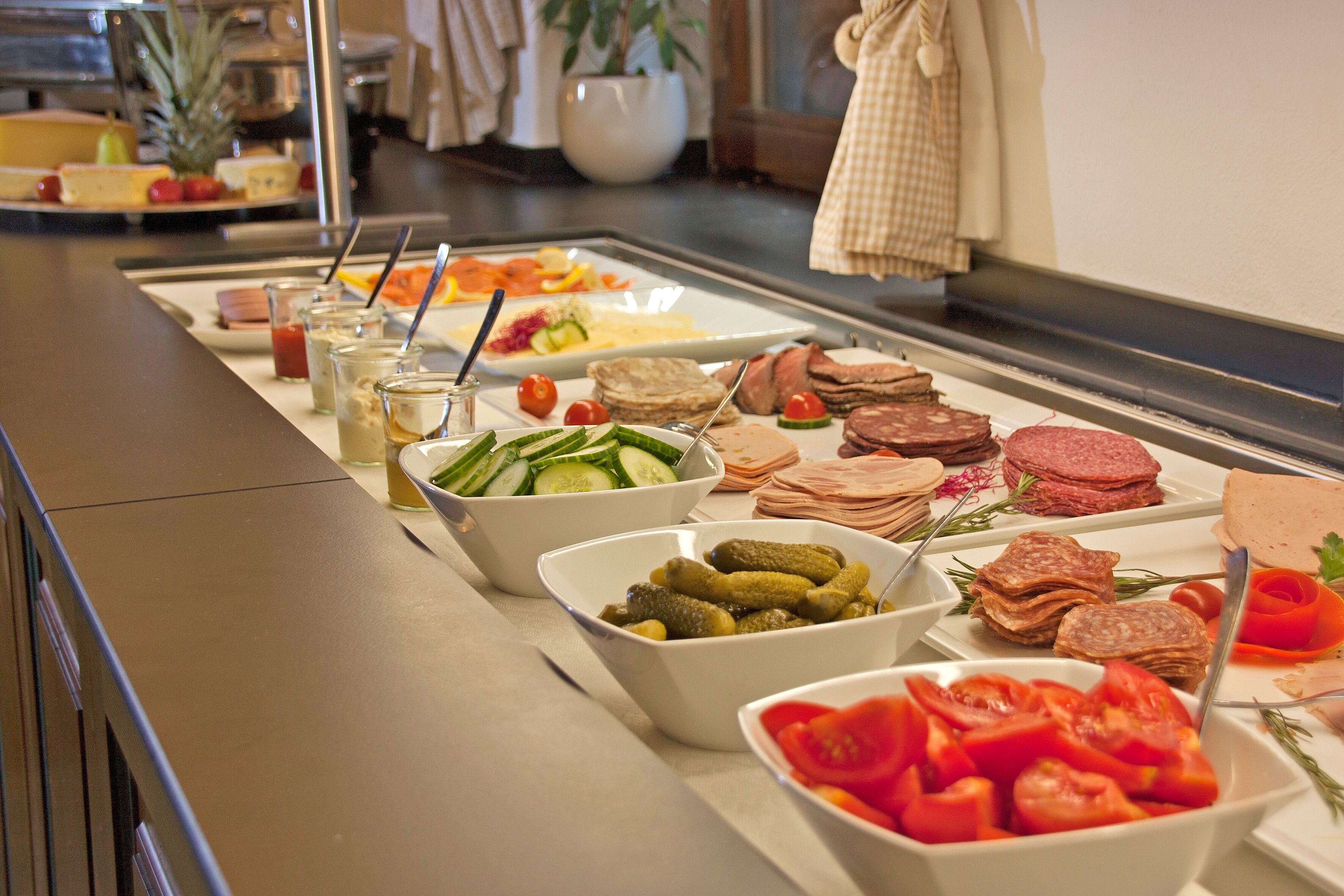 Un bufé con diversos alimentos, como ensaladas, carnes y verduras.