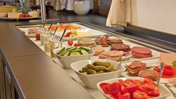 Buffet com diversos pratos, incluindo saladas, carnes e legumes.
