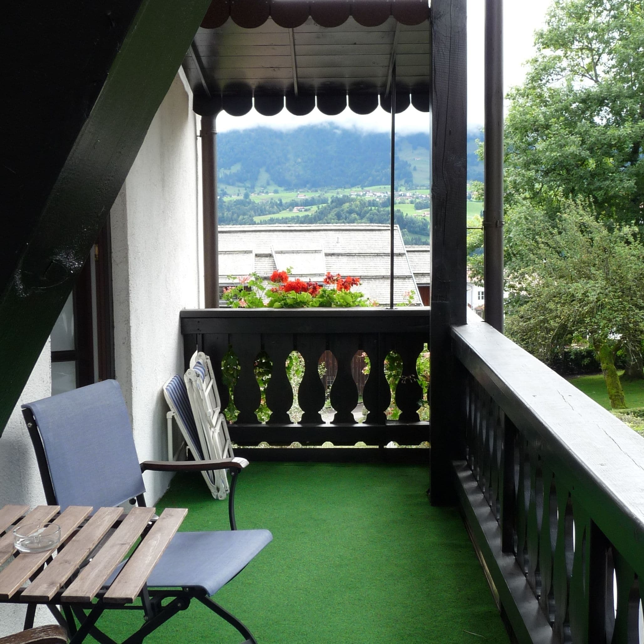 Ein Balkon mit Blick auf eine grüne Landschaft und Berge.