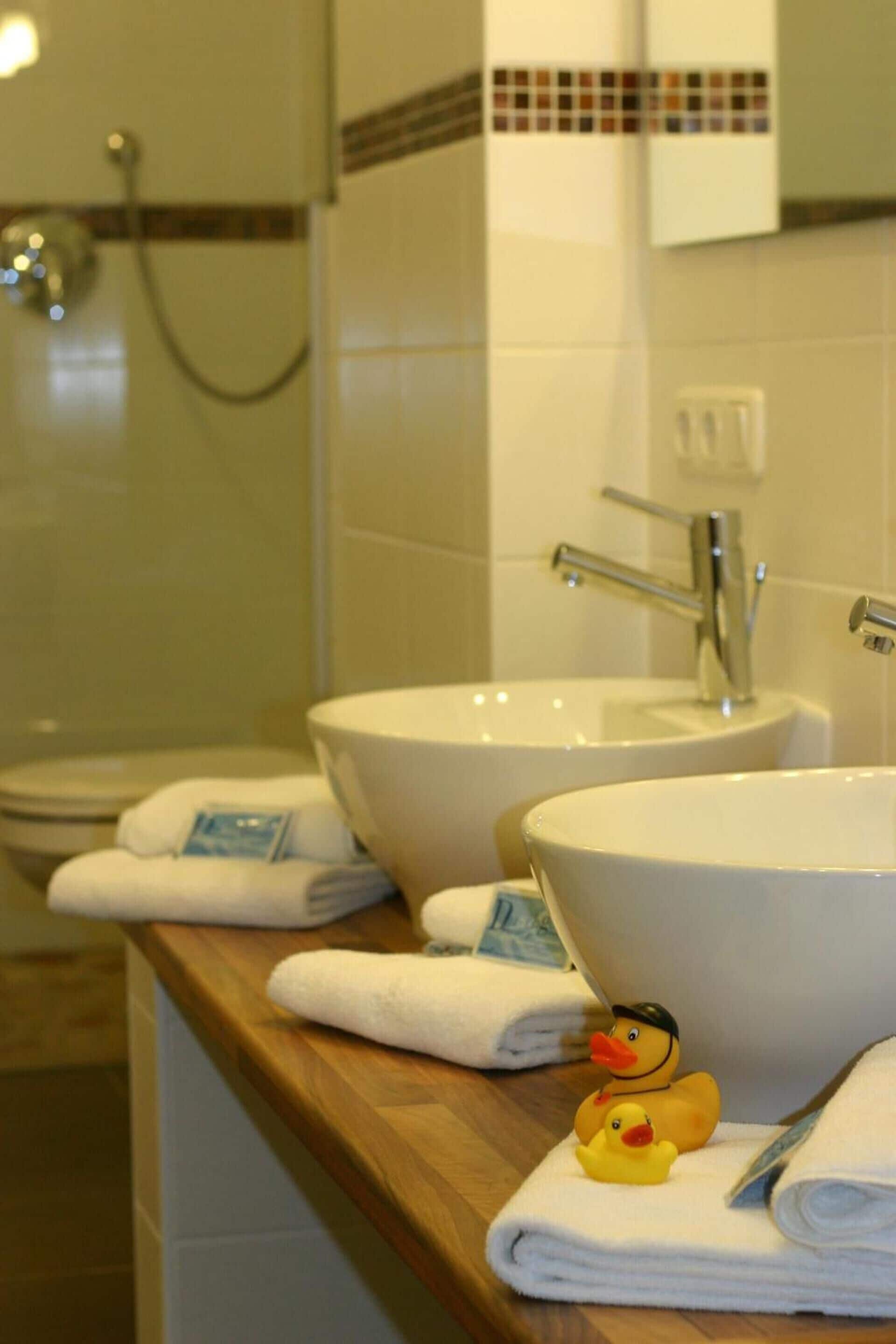 A bathroom with two sinks, a shower, and a mirror.