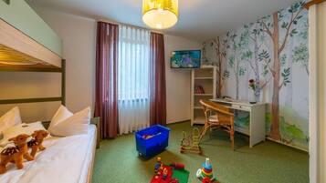 A hotel room with a bed, a desk, a television, and a bookshelf.