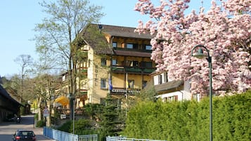 Un hotel de estilo arquitectónico tradicional, con un balcón y un letrero que indica que es un hotel.