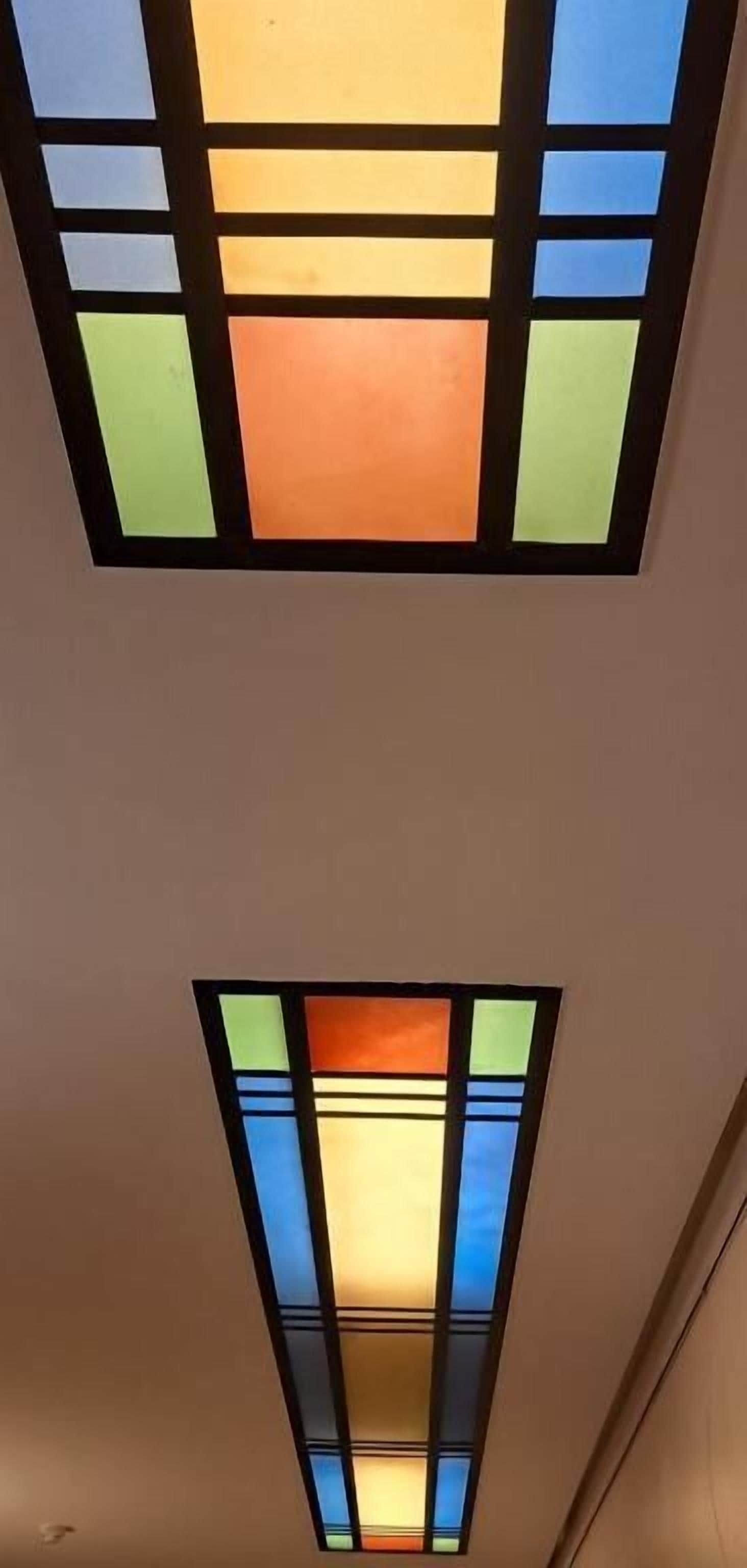 A ceiling with two rectangular stained glass panels.