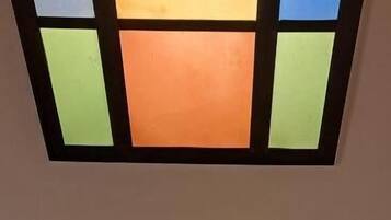 A ceiling with two rectangular stained glass panels.