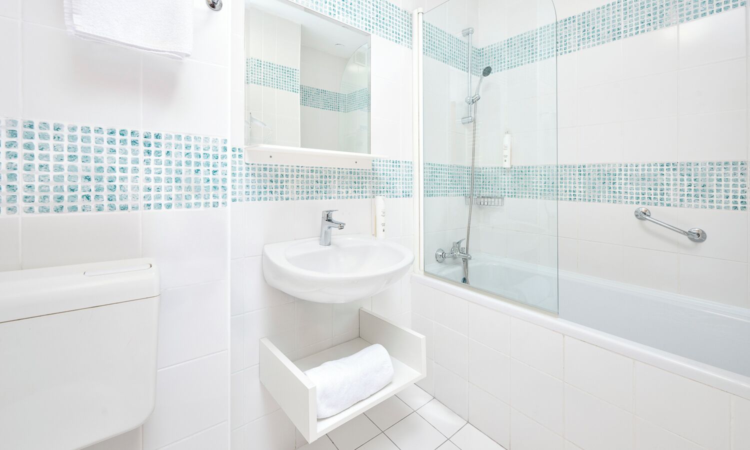 A modern bathroom with a toilet, sink, and glass-enclosed shower.