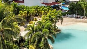 A multi-story hotel with balconies, a pool area, and a beach view. - Hotel Arena Blanca (San Andrés)