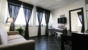 Una sala de estar moderna con un sofá, una mesa de comedor, un televisor y un escritorio.