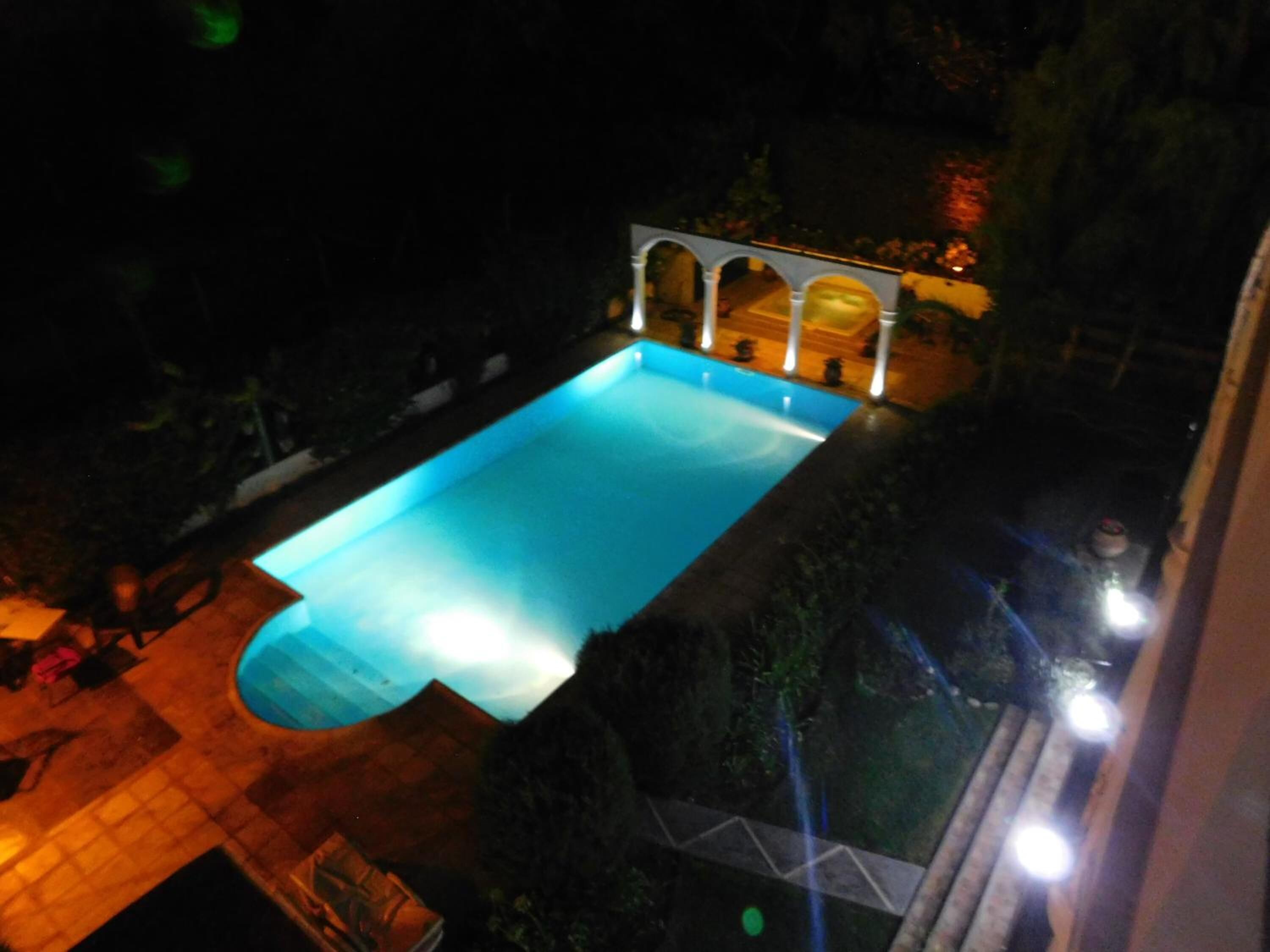 Una piscina al aire libre, sillones reclinables de piscina