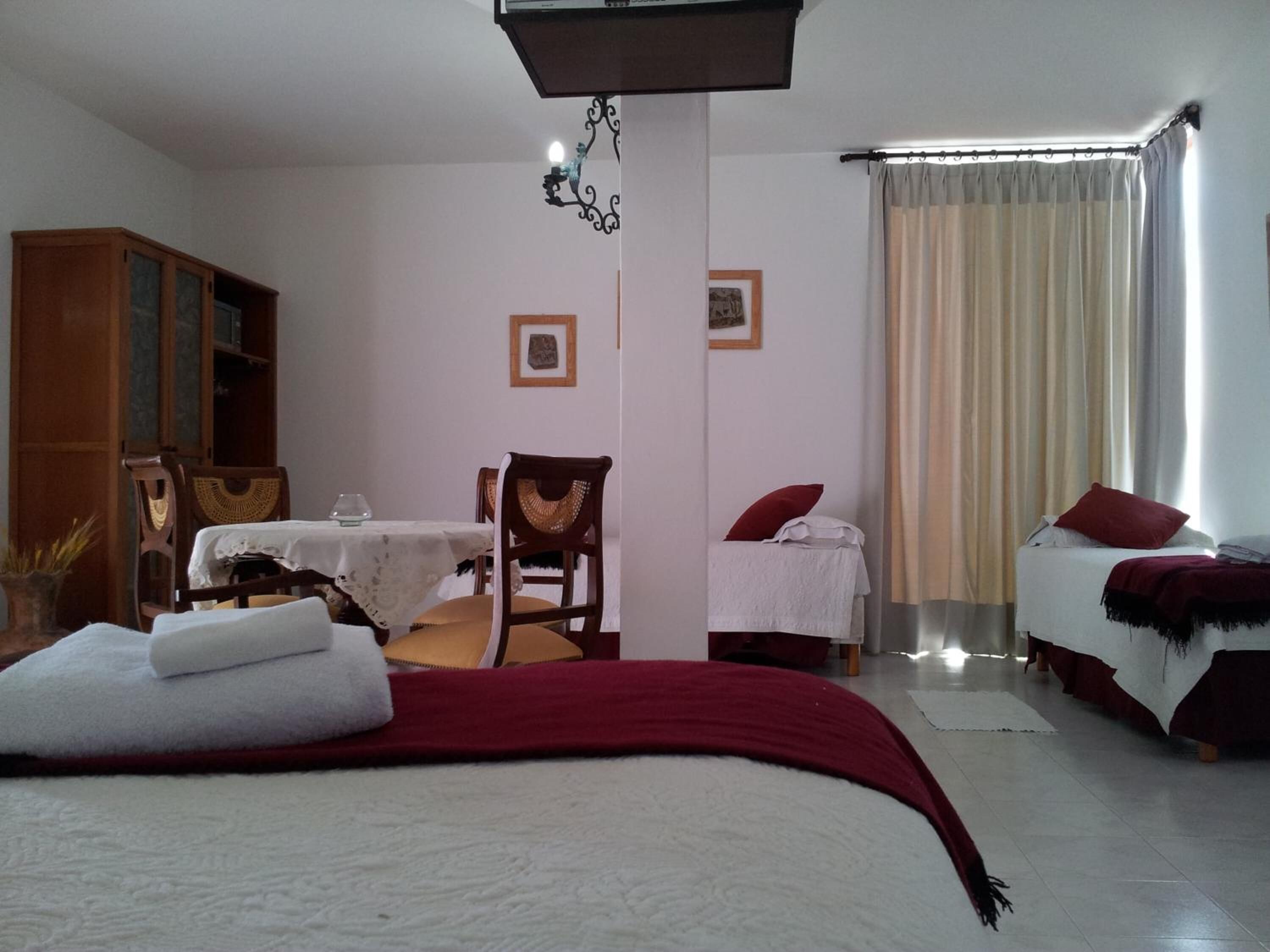 A bedroom with a bed, a desk, a chair, and a wardrobe.