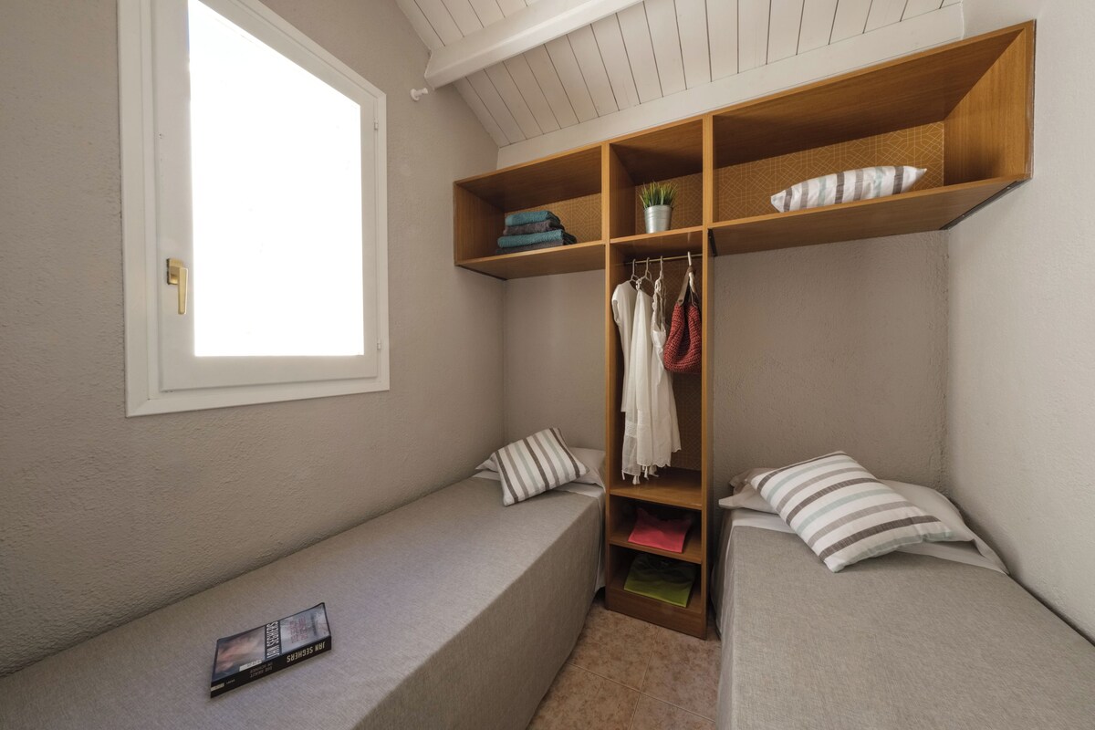 Quarto com closet embutido, janela e um banco.