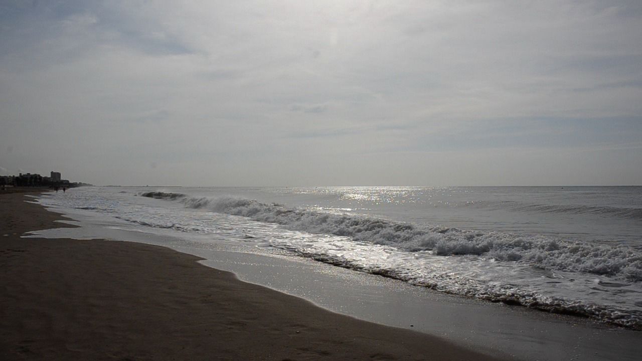 Una playa con olas que acarician suavemente la orilla.