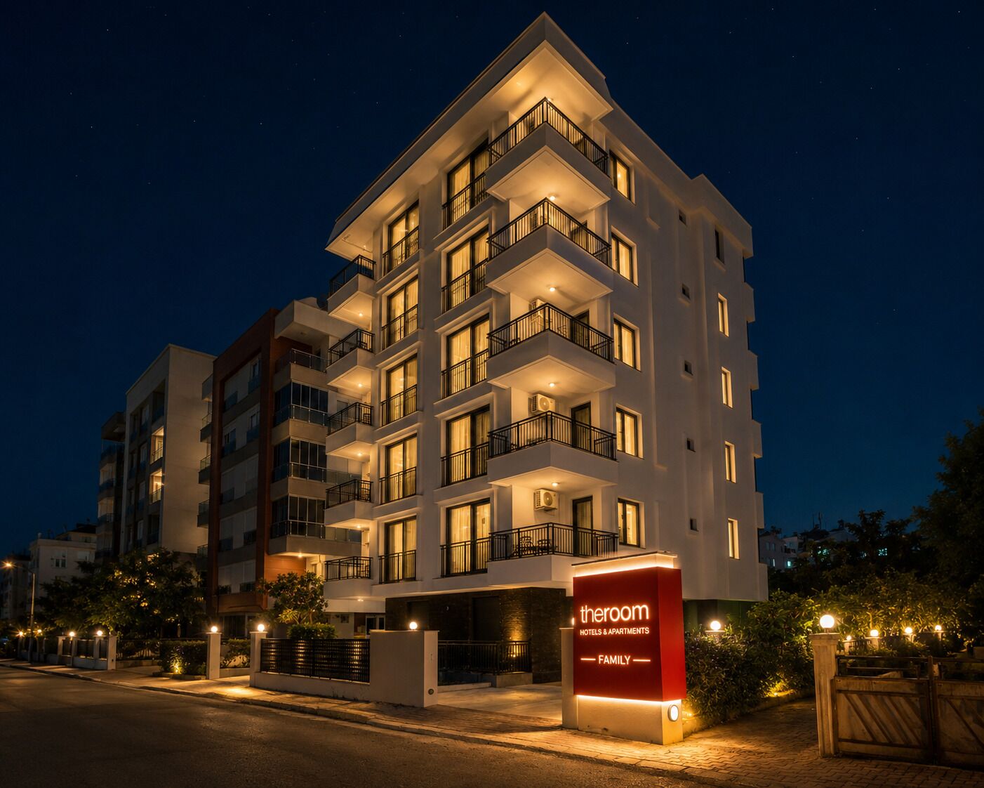 A multi-story hotel with balconies, a sign indicating it's a family hotel, and a gated entrance.