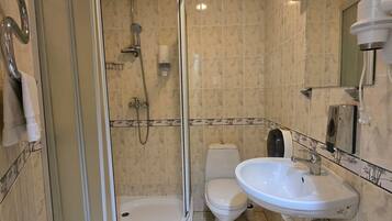 Un baño con ducha, inodoro y lavabo.