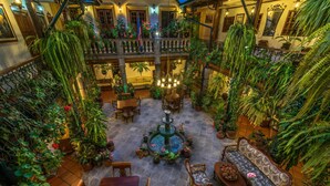 A multi-level atrium with a central fountain, surrounded by seating areas and lush greenery. - Hotel San Francisco de Quito (Quito)