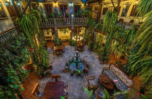 A multi-level atrium with a central fountain, surrounded by seating areas and lush greenery.