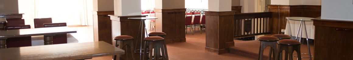A conference room with a long table, several chairs, and a high table with stools.