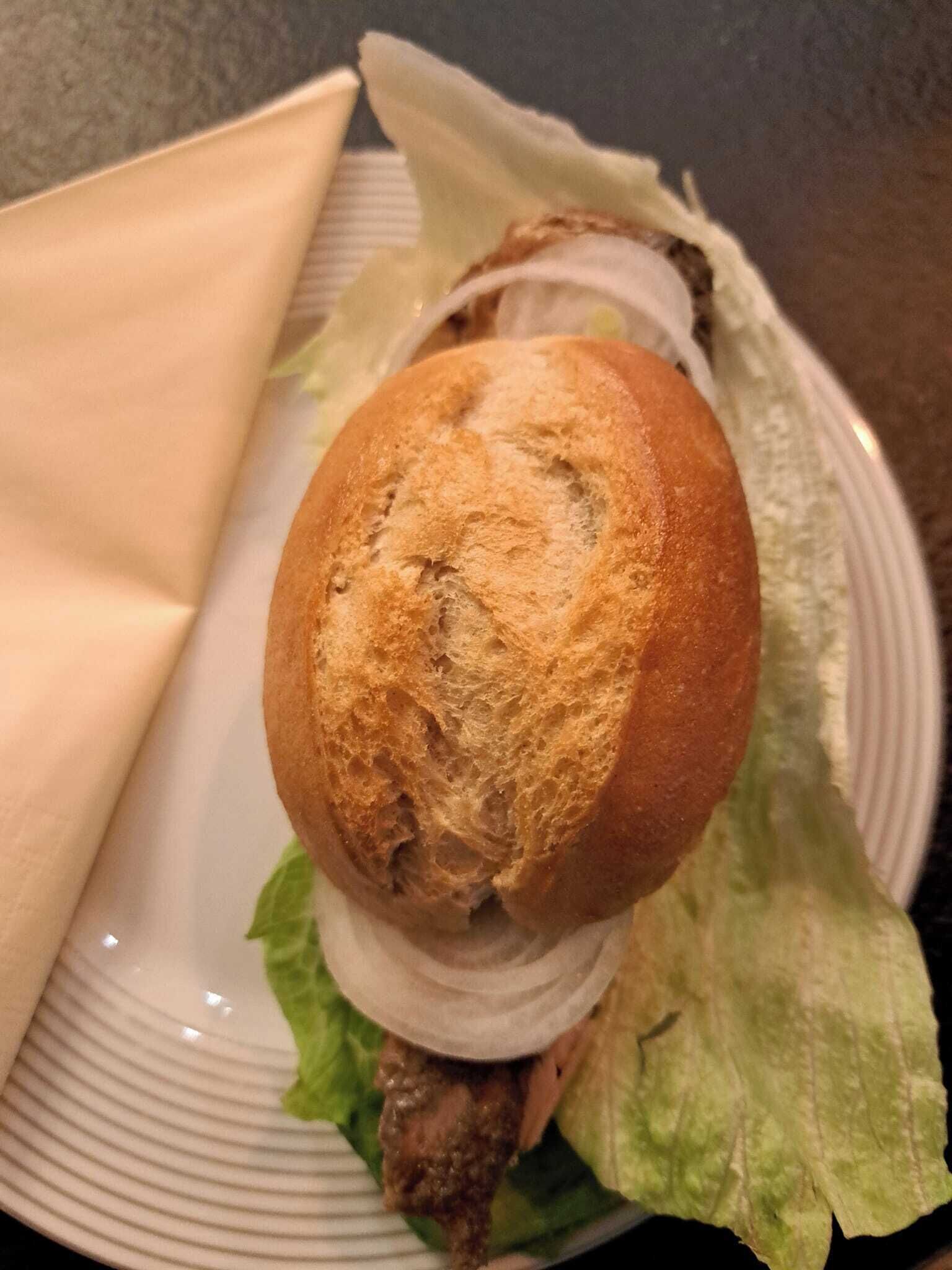 Ein Sandwich mit Salat und Brötchen auf einem Teller.
