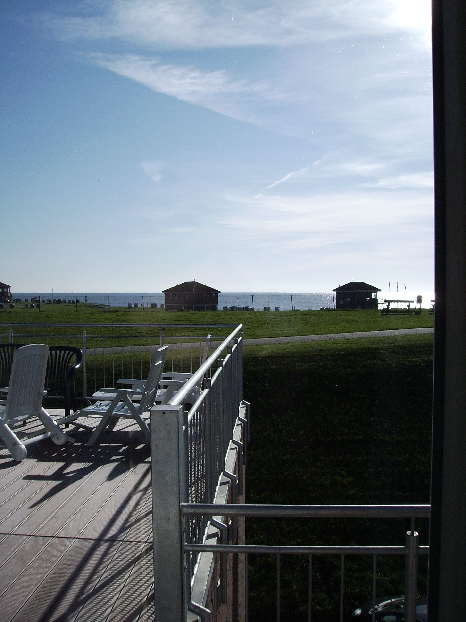 Una terrazza con sedie e vista sul mare.