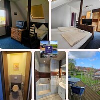 Habitación de hotel con cama, escritorio, silla, televisión y baño pequeño.