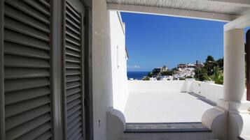 Un balcón con vista a un pueblo costero y al mar.