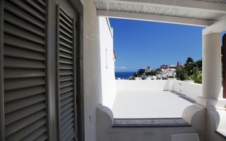 Un balcón con vista a un pueblo costero y al mar.