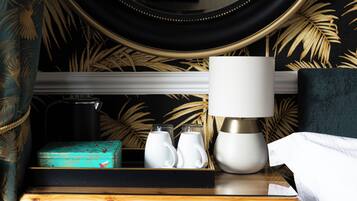 A neatly arranged bedside table with a lamp, two white mugs, and a teal box.