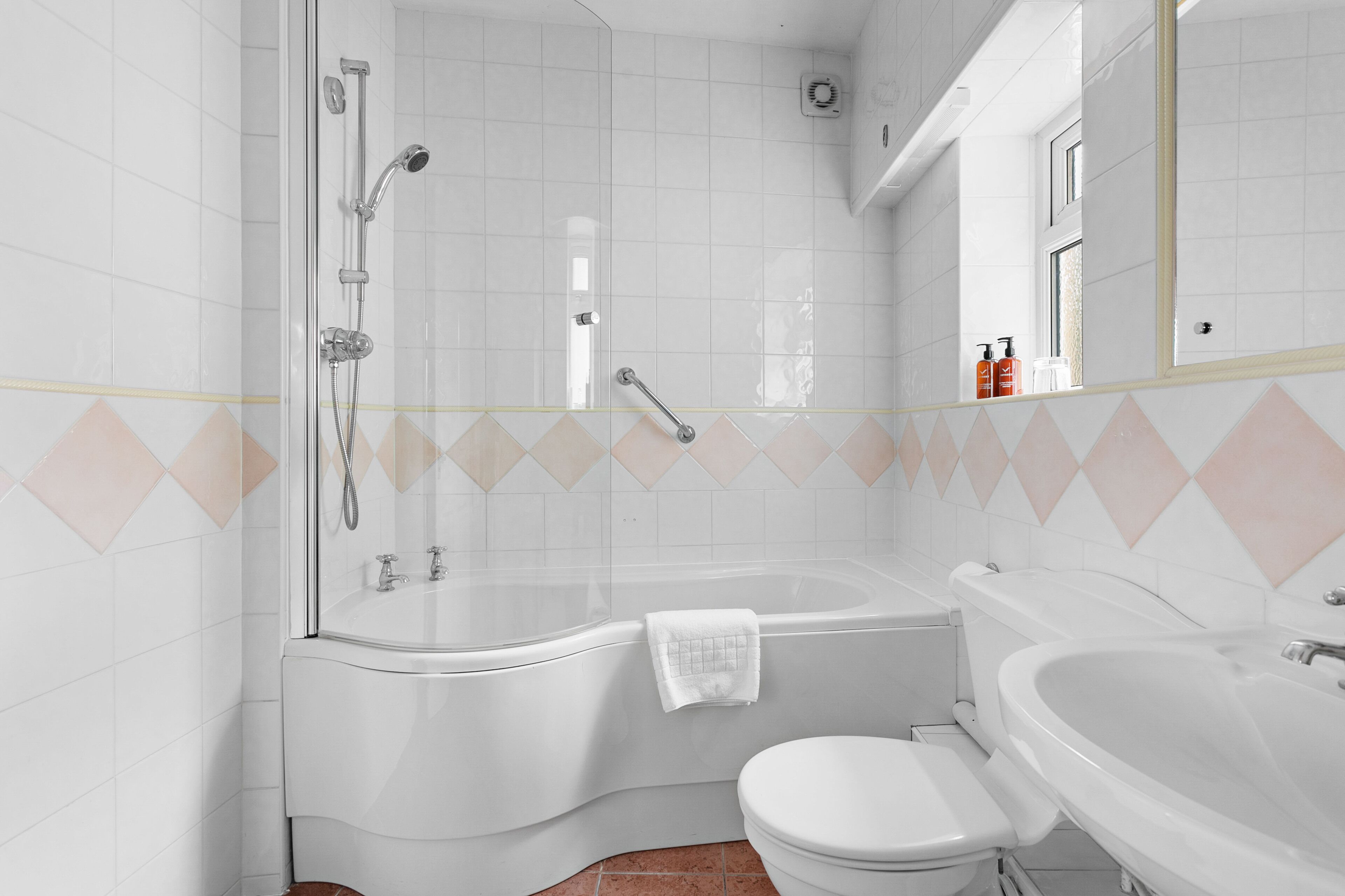 Ein Badezimmer mit einer Glasdusche, einer freistehenden Badewanne, einer Toilette und einem Waschbecken.