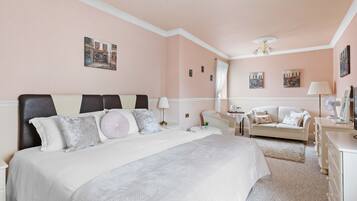 Una habitación de hotel con una cama grande, un sofá, un escritorio y una silla.