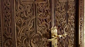 A detailed wooden door with intricate carvings and a brass handle.