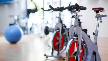 A row of stationary bikes in a gym with exercise balls in the background.