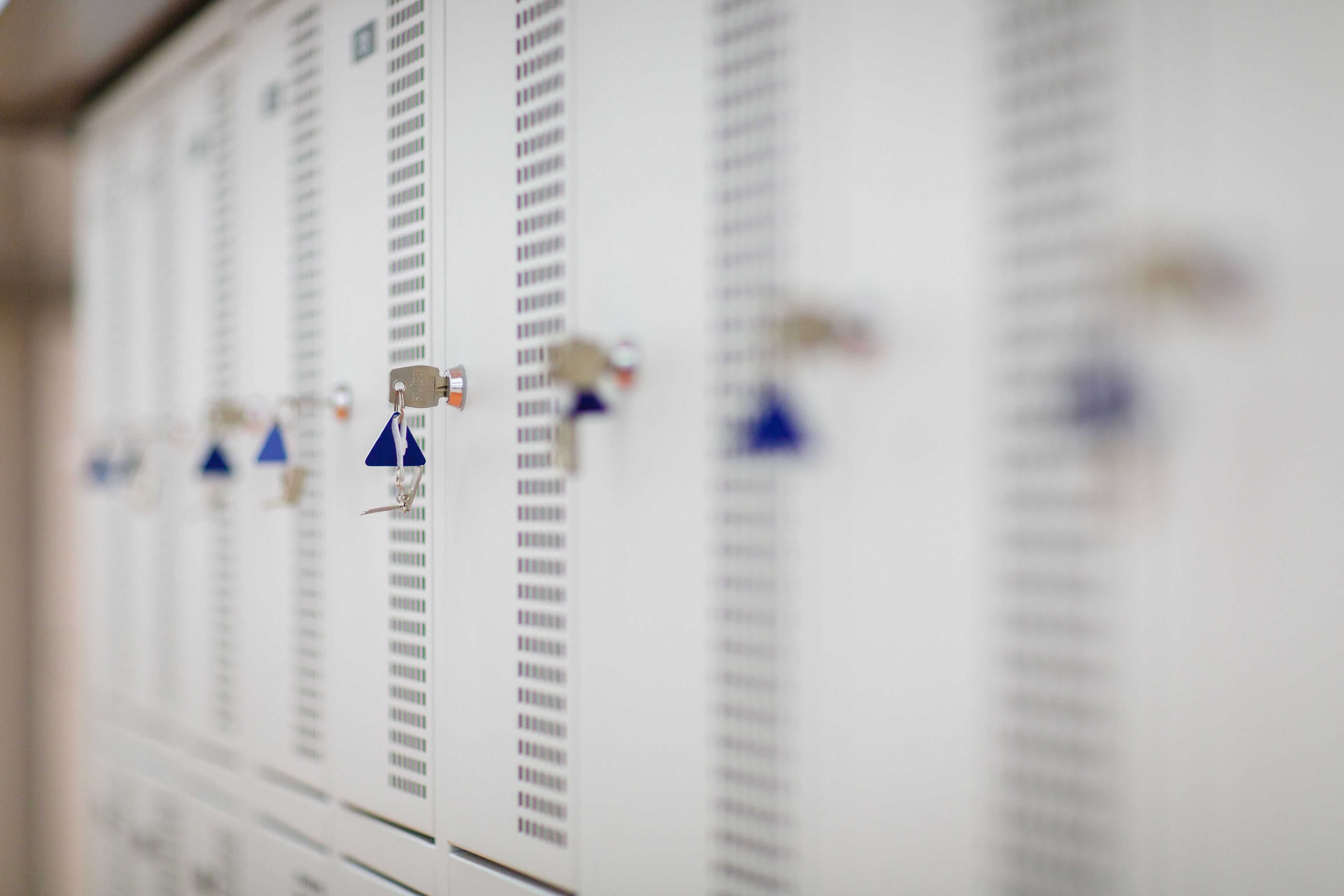 A row of lockers with blue tags.