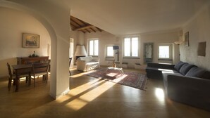 Un salón amplio con una mesa de comedor de madera, un sofá y una chimenea.