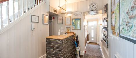 A reception area with a stone counter, framed pictures on the walls, a clock, and a map.