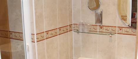 Un bagno con il water, un lavandino e uno sportello doccia in vetro.