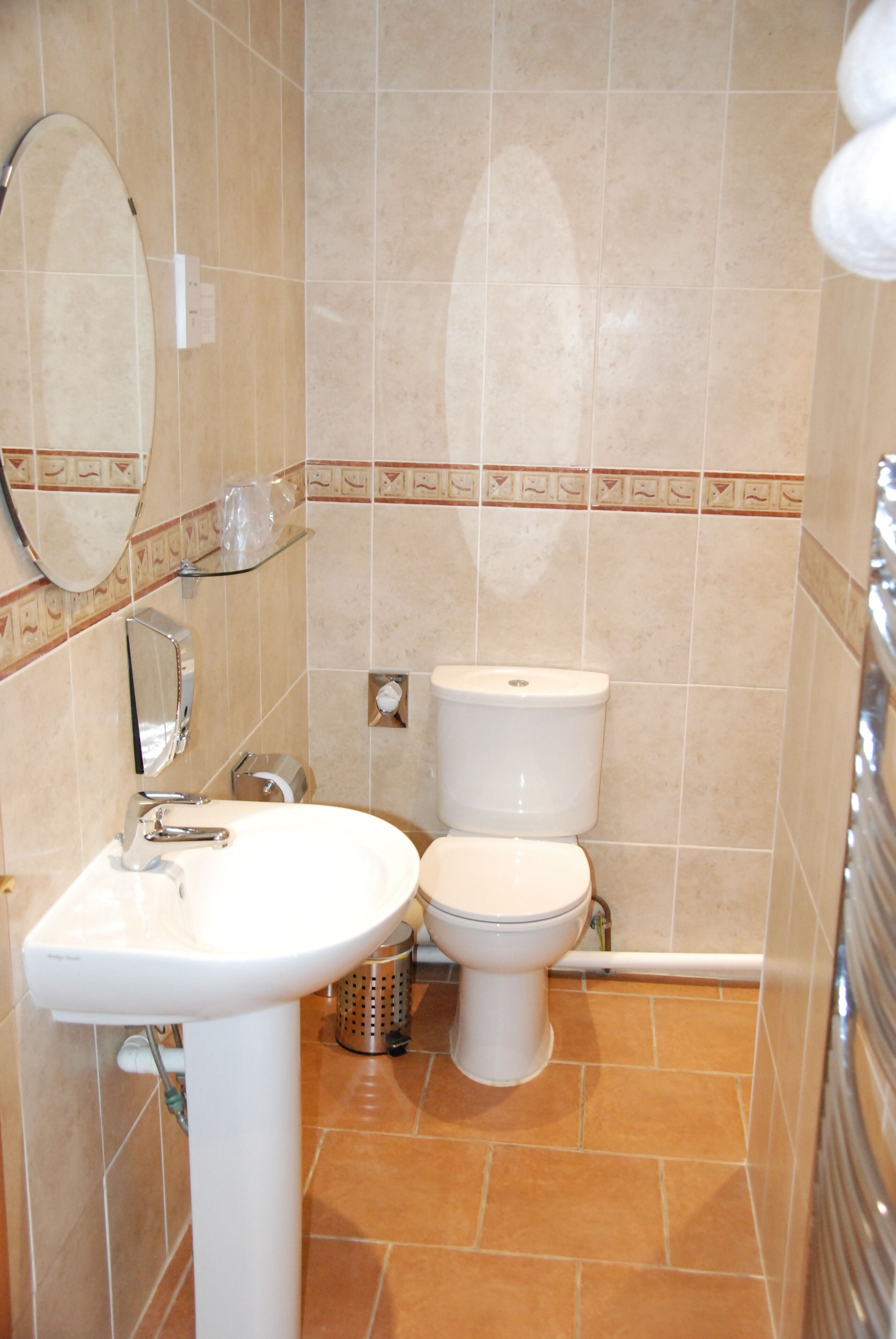 Un baño con un lavamanos blanco, un inodoro y un espejo.