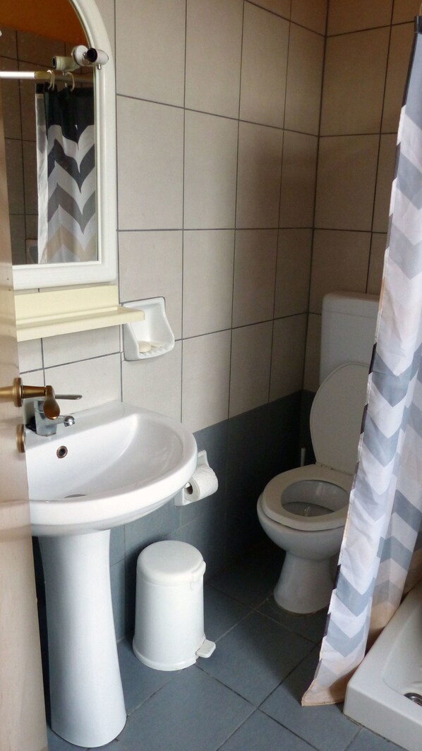 Une salle de bain avec un lavabo, des toilettes et un bidet, le tout de couleur blanche.